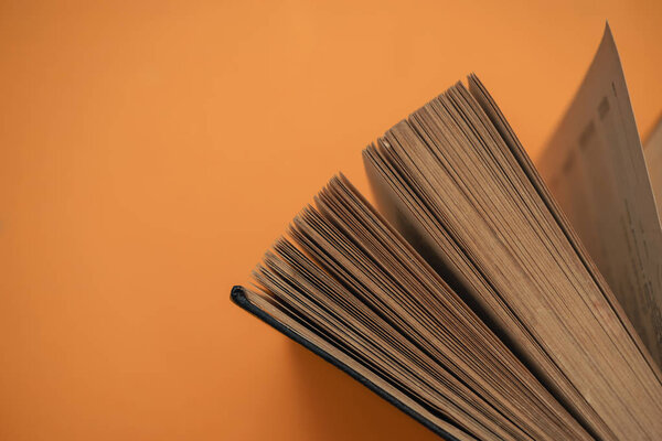 Open book on a yellow background. Top view.