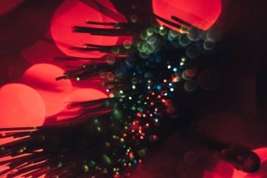 Kırmızı bokeh arka plan üzerinde güzel çok renkli soyut optik fiber çizgi.