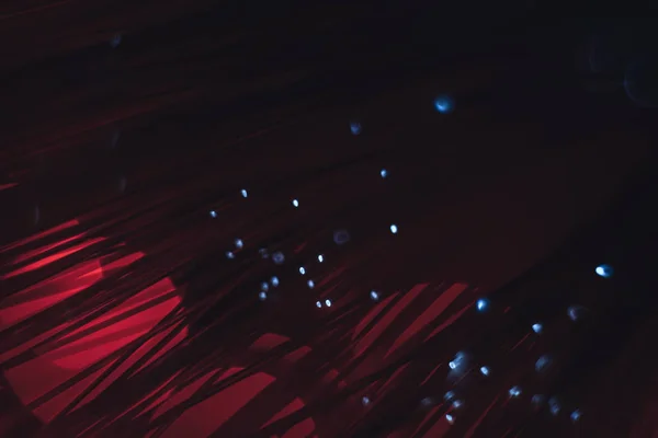 Beautiful abstract optical fiber line on a red bokeh background.