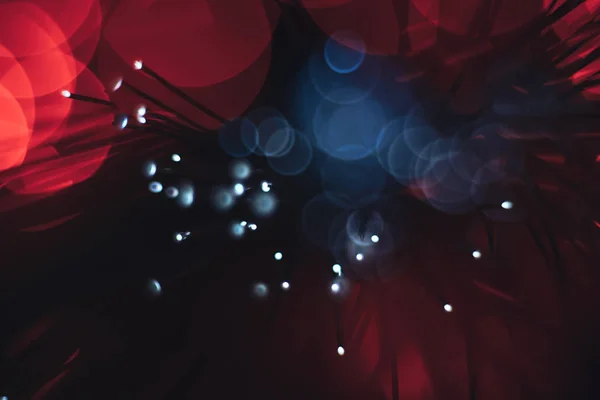 Beautiful abstract optical fiber line on a red bokeh background.