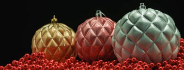 Güzel Noel baubles ve boncuklar ahşap bir masa ve siyah arka plan üzerinde yakın.