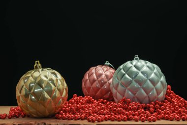 Güzel Noel baubles ve boncuklar ahşap bir masa ve siyah arka plan üzerinde yakın.
