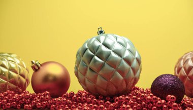 Yakın güzel Noel süsler ve boncuklar ahşap bir masa ve sarı arka plan üzerinde yakın.