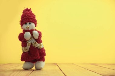 Güzel Noel baubles kardan adam kırmızı ahşap masa ve sarı arka plan üzerinde Noel Baba giyinmiş.