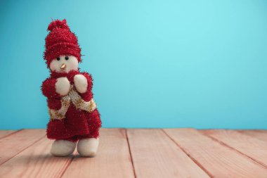 Güzel Noel baubles kardan adam kırmızı ahşap masa ve mavi arka plan üzerinde Noel Baba giyinmiş.