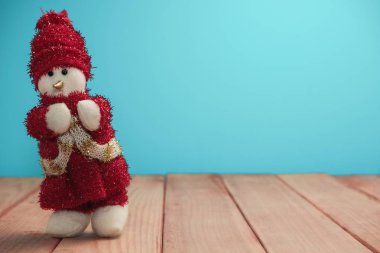 Güzel Noel baubles kardan adam kırmızı ahşap masa ve mavi arka plan üzerinde Noel Baba giyinmiş.