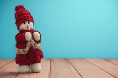 Güzel Noel baubles kardan adam kırmızı ahşap masa ve mavi arka plan üzerinde Noel Baba giyinmiş.