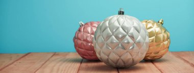 Güzel Noel baubles ve boncuklar ahşap bir masa ve mavi arka plan üzerinde yakın.