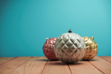 Güzel Noel baubles ve boncuklar ahşap bir masa ve mavi arka plan üzerinde yakın.