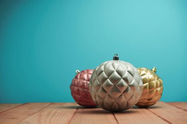 Güzel Noel baubles ve boncuklar ahşap bir masa ve mavi arka plan üzerinde yakın.