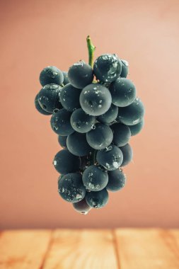 Kırmızı ahşap masa ve kırmızı duvar arka plan üzerinde güzel şarap menekşe üzüm.