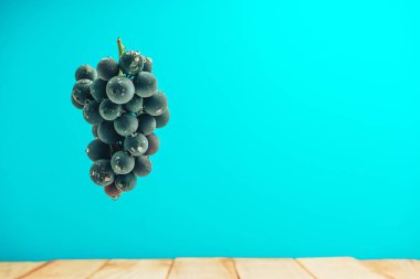 Kırmızı ahşap masa ve mavi duvar arka plan üzerinde güzel şarap menekşe üzüm.