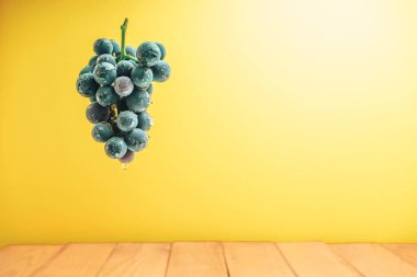 Kırmızı ahşap masa ve sarı duvar arka plan üzerinde güzel şarap menekşe üzüm.