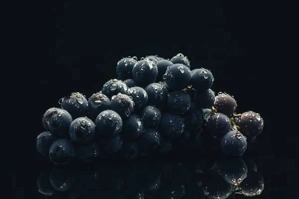 美丽的新鲜葡萄蓝葡萄在黑色玻璃桌上和黑暗的背景 — 图库照片