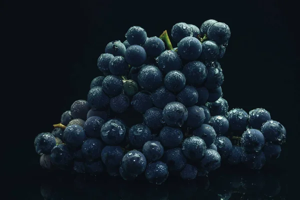 黑色玻璃桌上的新鲜葡萄蓝葡萄和深色背景 — 图库照片