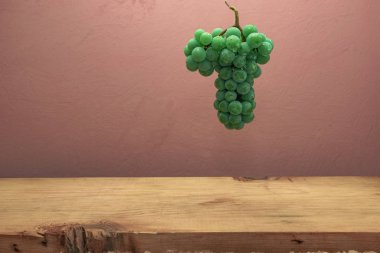 Kahverengi ahşap masa ve koyu kırmızı duvar arka plan üzerinde güzel taze beyaz asma üzüm.