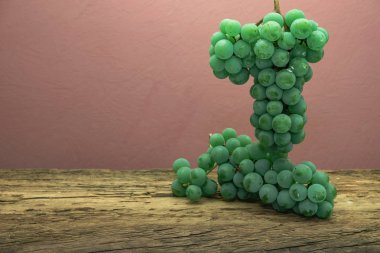 Eski bir meşe ahşap masa ve koyu kırmızı duvar arka plan üzerinde güzel taze beyaz asma üzüm.