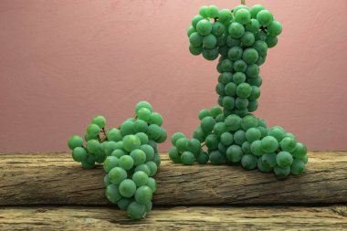 Eski bir meşe ahşap masa ve koyu kırmızı duvar arka plan üzerinde güzel taze beyaz asma üzüm.