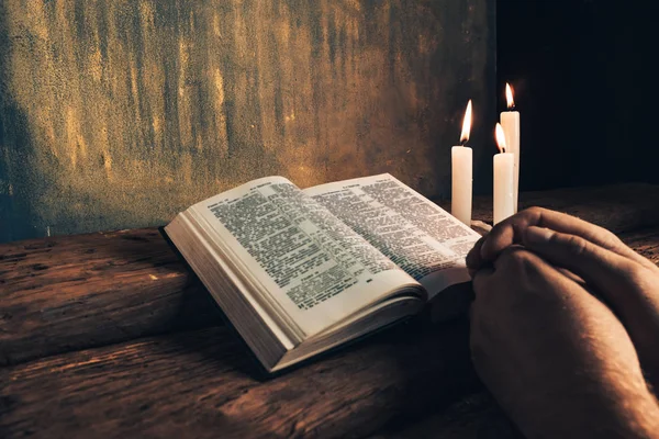 特写人坐在一张桌子前 在一张古老的橡木桌和金墙背格上读圣经 — 图库照片