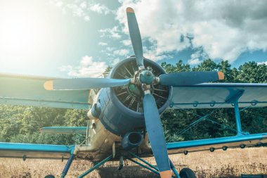 Bir orman ve gökyüzü arka plan üzerinde güzel mavi ve sarı uçak. Vintage uçak.