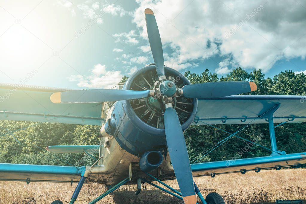 Beautiful blue and yellow airplane on a forest and sky background. Vintage aircraft.