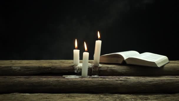Schöne Offene Bibel Und Brennende Kerzen Auf Einem Alten Eichentisch — Stockvideo