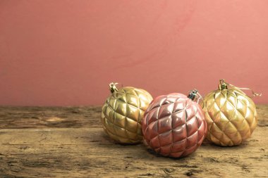 Eski bir meşe ahşap masa ve kırmızı duvar arka plan üzerinde Güzel Noel bauble.