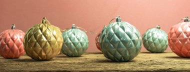 Eski bir meşe ahşap masa ve kırmızı duvar arka plan üzerinde Güzel Noel bauble.