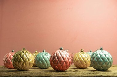 Eski bir meşe ahşap masa ve kırmızı duvar arka plan üzerinde Güzel Noel bauble.