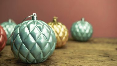 Eski bir meşe ahşap masa ve kırmızı duvar arka plan üzerinde Güzel Noel bauble kapatın.