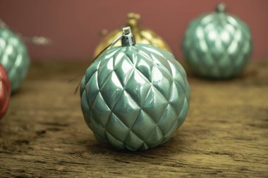 Eski bir meşe ahşap masa ve kırmızı duvar arka plan üzerinde Güzel Noel bauble kapatın.