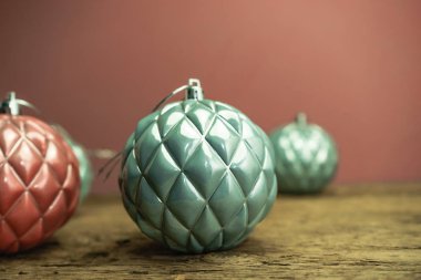 Eski bir meşe ahşap masa ve kırmızı duvar arka plan üzerinde Güzel Noel bauble kapatın.