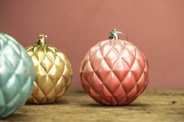 Eski bir meşe ahşap masa ve kırmızı duvar arka plan üzerinde Güzel Noel bauble kapatın.