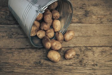 Eski bir meşe ahşap masa ve güzel bir arka plan üzerinde gümüş sepettaze patates. Üstte görüntü.