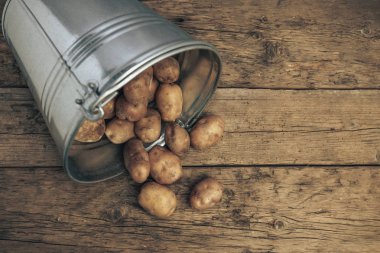Eski bir meşe ahşap masa ve güzel bir arka plan üzerinde gümüş sepettaze patates. Üstte görüntü.