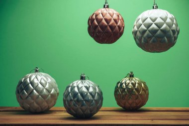 Ahşap kırmızı masa ve yeşil duvar arka plan üzerinde Güzel Noel baubles.