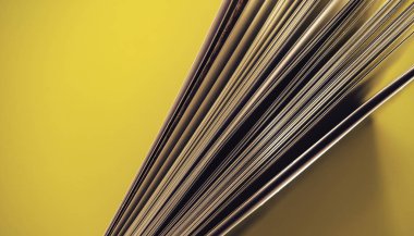 Sarı arka plan masasında güzel kitap üst görünümü kadar yakın.