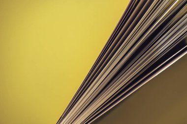 Sarı arka plan masasında güzel kitap üst görünümü kadar yakın.