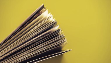 Sarı arka plan masasında güzel kitap üst görünümü kadar yakın.
