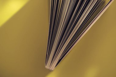 Sarı arka plan masasında güzel kitap üst görünümü kadar yakın.