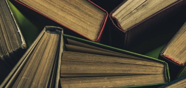 Yeşil arka plan masasında eski kitapları açın. Üstte görüntü.