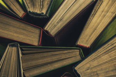 Yeşil arka plan masasında eski kitapları açın. Üstte görüntü.