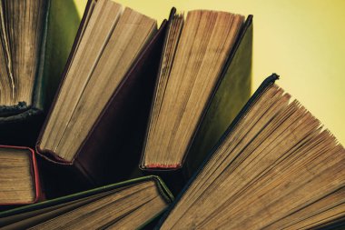 Yeşil arka plan masasında eski kitapları açın. Üstte görüntü.