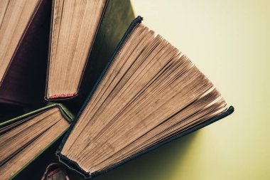 Yeşil arka plan masasında eski kitapları açın. Üstte görüntü.