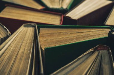 Yeşil arka plan masasında eski kitapları açın. Üstte görüntü.