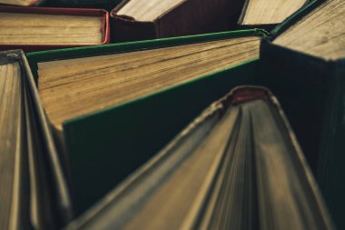 Yeşil arka plan masasında eski kitapları açın. Üstte görüntü.