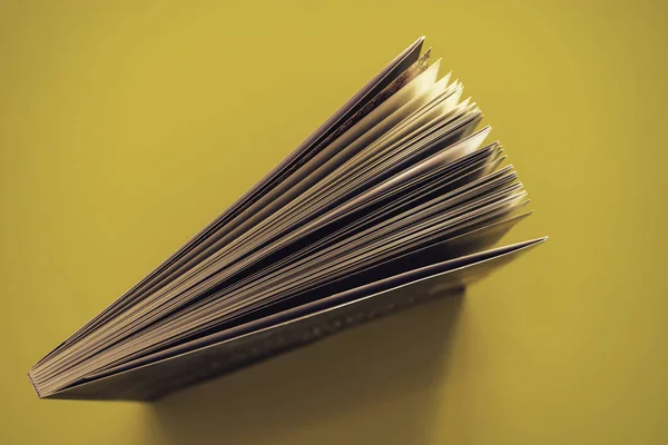 Beautiful book top view on a yellow background table.