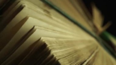 Karanlık bir arka plan üzerinde güzel eski sayfalar kitap rotasyon kadar kapatın.