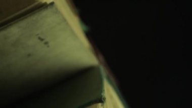 Karanlık bir arka plan üzerinde güzel eski sayfalar kitap rotasyon kadar kapatın.