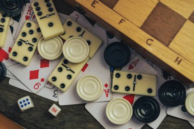 Çeşitli masa oyunları, satranç tahtası, eski tahta bir arka planda domino taşları..